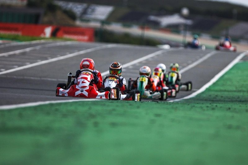 Khalid leading a train of karts at Portimão, his Bahrain-flag helmet at the front